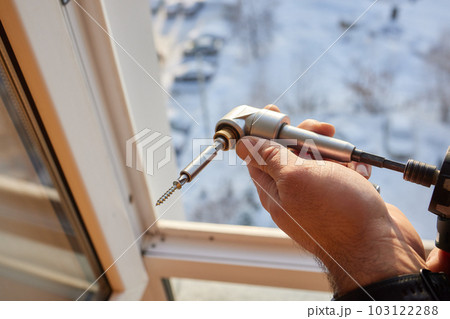 The worker installing and checking window in the house. 103122288