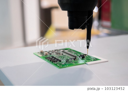 Automatic manipulator with dispenser needle during work with SMT pcb - close up 103123452