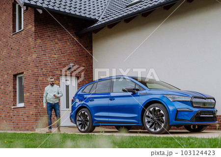 Mature man waiting for charging his electric car. Mature man waiting for charging his electric car. 103124423