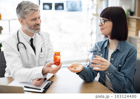 Lady receiving oral medicine from physician at hospital 103124480