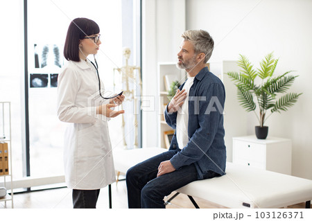 Patient talking about chest pain with medical specialist Patient talking about chest pain with medical specialist 103126371