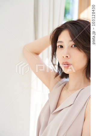 窓際で日差しを浴びる若い女性 103128430