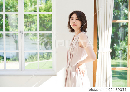 窓際で日差しを浴びる若い女性 103129051