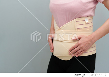 woman wearing lumbar support belts. pregnant and postnatal lumbar brace woman wearing lumbar support belts. pregnant and postnatal lumbar brace 103133685