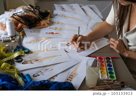 Faceless woman draws sketches of swimwear. Close-up of the hands of a fashion designer. 103133913