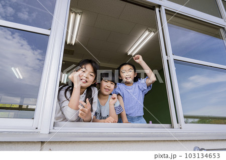 学校の教室の窓から運動場の生徒を応援する小学生の女の子 103134653