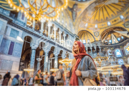 Woman tourist enjoying Hagia Sofia, Ayasofya interior in Istanbul, Turkey, Byzantine architecture, city landmark and architectural world wonder. Turkiye Woman tourist enjoying Hagia Sofia, Ayasofya interior in Istanbul, Turkey, Byzantine architecture, city landmark and architectural world wonder. Turkiye 103134676