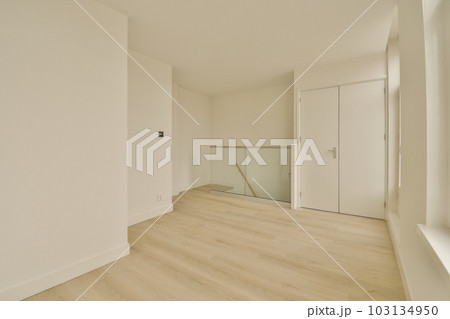 an empty room with white walls and wood flooring on the right, there is a mirror in the corner an empty room with white walls and wood flooring on the right, there is a mirror in the corner 103134950