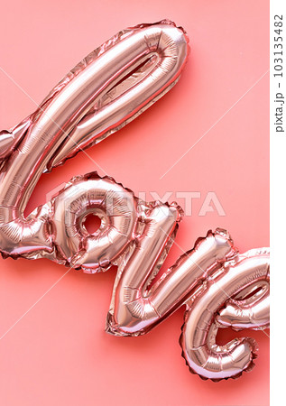 Love made from foil balloons on pink. Monochrome image. 103135482