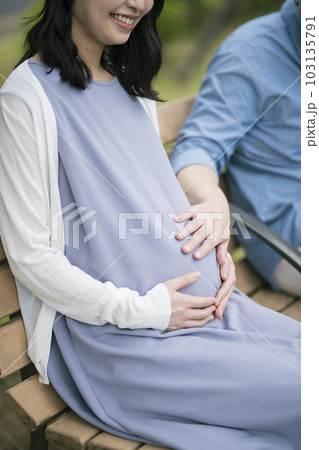 公園で休憩する妊婦と夫 103135791