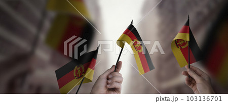 A group of people holding small flags of the DDR in their hands 103136701