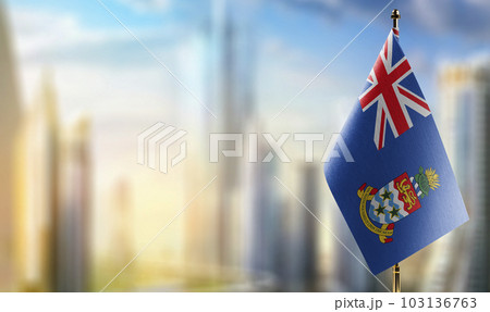 Small flags of the Cayman Islands on an abstract blurry background 103136763