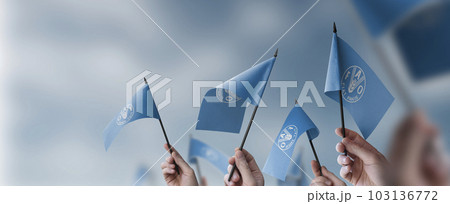 A group of people holding small flags of the Food and agriculture organization in their hands 103136772