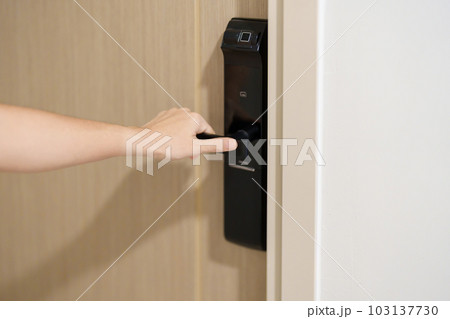Hand using smart digital door lock while open or close the door at home or apartment. NFC Technology, Fingerprint scan, keycard, PIN number, smartphone, electrical and contactless lifestyle concepts Hand using smart digital door lock while open or close the door at home or apartment. NFC Technology, Fingerprint scan, keycard, PIN number, smartphone, electrical and contactless lifestyle concepts 103137730