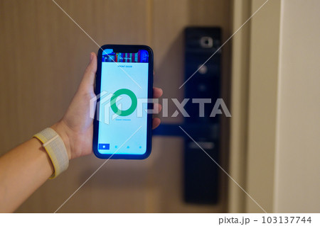 Hand using smartphone for open digital door lock at home or apartment. NFC Technology, Fingerprint scan, keycard, PIN number, smartphone, electrical and contactless lifestyle concepts 103137744