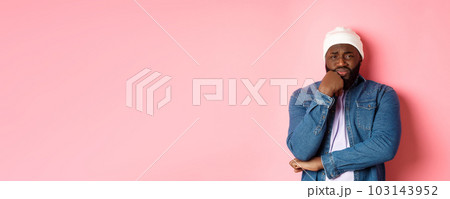Young african-american man look with pity and concern at camera, frowning and feeling uneasy, standing over pink background 103143952