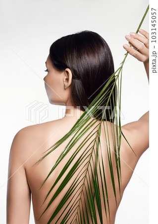 beautiful girl with palm leaves. young naked woman spine beautiful girl with palm leaves. young naked woman spine 103145057