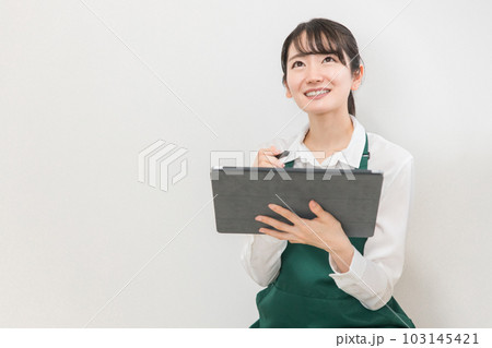 コンビニ・スーパーでタブレット端末を使って在庫管理・棚卸しをする店員・バイトの女性 コンビニ・スーパーでタブレット端末を使って在庫管理・棚卸しをする店員・バイトの女性 103145421