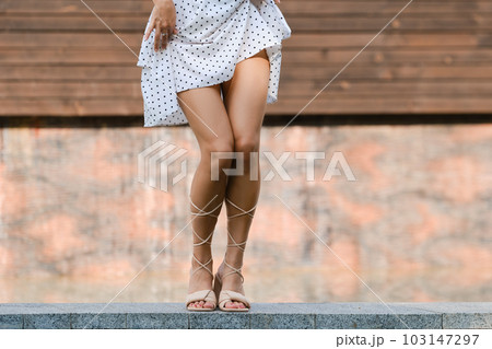 Beautiful woman dancing outdoor, squatting legs 103147297
