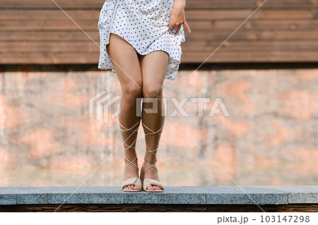 Cute woman dancing outdoor, squatting legs 103147298