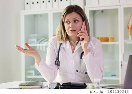 Doctor talks to patient on phone listening to complaints 103150318