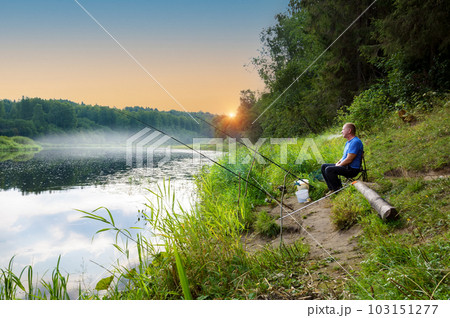 In the early summer morning, a fisherman is fishing in the upper reaches of the Volga River. 103151277