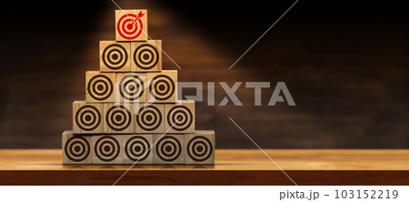 Stack of Wooden Blocks with Many Brown Targets and One Red One 103152219