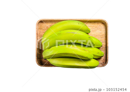 Green bananas on a wooden tray. Isolated on white background. 103152454