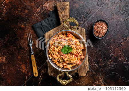 Turkish Menemen omelet with vegetabls and sucuk in askillet. Dark background. Top view Turkish Menemen omelet with vegetabls and sucuk in askillet. Dark background. Top view 103152560