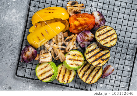 Seasonal summer Grilled vegetables on a grill, bell pepper, zucchini, eggplant, onion and tomato. Gray background. Top view 103152646