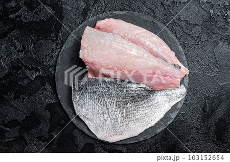 Raw Sea bream Dorado fish fillets. Black background. Top view Raw Sea bream Dorado fish fillets. Black background. Top view 103152654