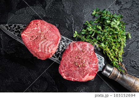 Fillet Mignon Beef steak, raw dry aged marble meat. Black background. Top view 103152694
