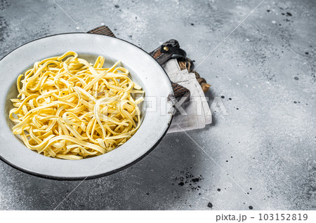 Raw dried spaetzle egg noodle. Gray background. Top view. Copy space 103152819