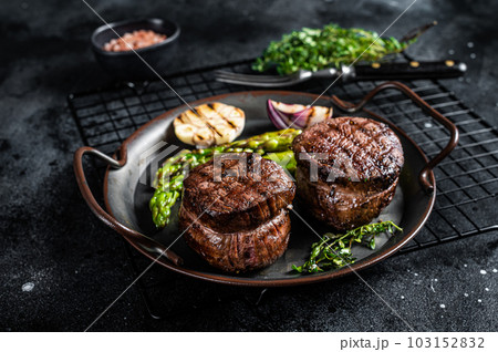 Grilled Fillet Mignon Steak with roasted asparagus. Black background. Top view 103152832