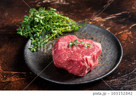Prime Fillet Mignon Beef steak, Dry aged raw tenderloin meat. Dark background. Top view 103152842