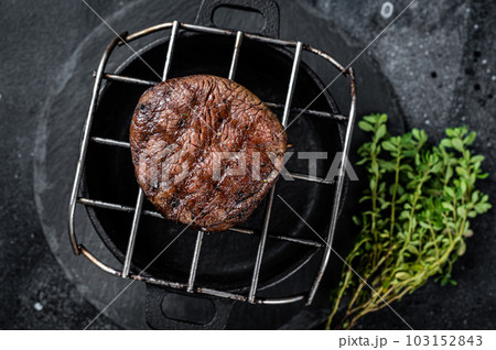 Fillet Mignon grilled beef Steak on a grill. Black background. Top view Fillet Mignon grilled beef Steak on a grill. Black background. Top view 103152843