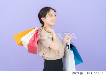 パープルバックでショッピングをして買い物袋を持つ若い女性 103155103