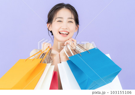 パープルバックでショッピングをして買い物袋を持つ若い女性 103155106