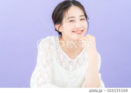 パープルバックでスキンケアをする若い女性 103155109