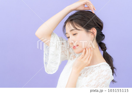 パープルバックでスキンケアをする若い女性 103155115