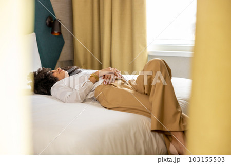 Young woman lying on bed in the hotel rooma and feeling relaxed 103155503