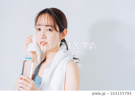 汗を拭くスポーツウェアの若い女性 103155793