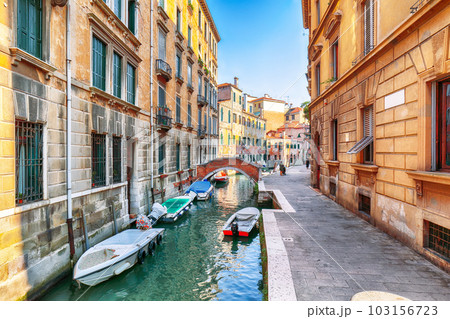 cityscape of Venice with narrow canals, boats and gondolas and bridges with traditional buildings 103156723