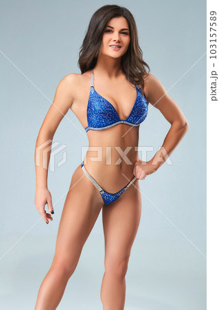 Sexy brunette bodybuilder woman in blue bikini. 103157589
