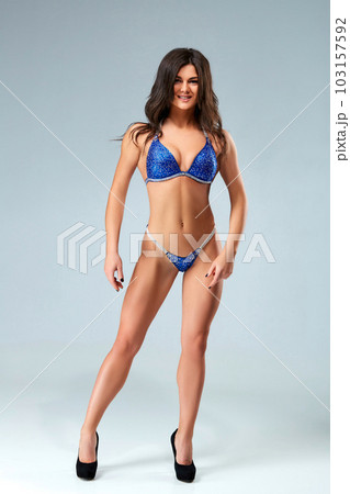 Sexy brunette bodybuilder woman in blue bikini. Sexy brunette bodybuilder woman in blue bikini. 103157592