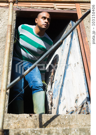 Portrait of man at doorway of building 103158406