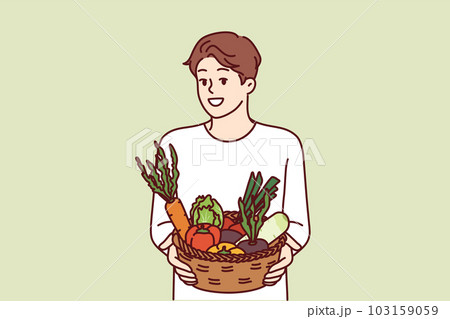 Man with basket of vegetables smiles and recommends going vegan or eating organic raw food 103159059