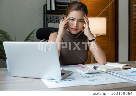 Tired stressed business woman suffering from headaches while working from home office Tired stressed business woman suffering from headaches while working from home office 103159664