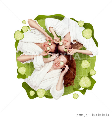 Three beautiful young girls in bathrobe doing mask with cucumber. Face lightning and vitamin care. Creative conceptual design. Three beautiful young girls in bathrobe doing mask with cucumber. Face lightning and vitamin care. Creative conceptual design. 103161613