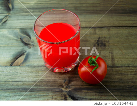 Tomato juice and tomato on a dark wooden table. 103164443